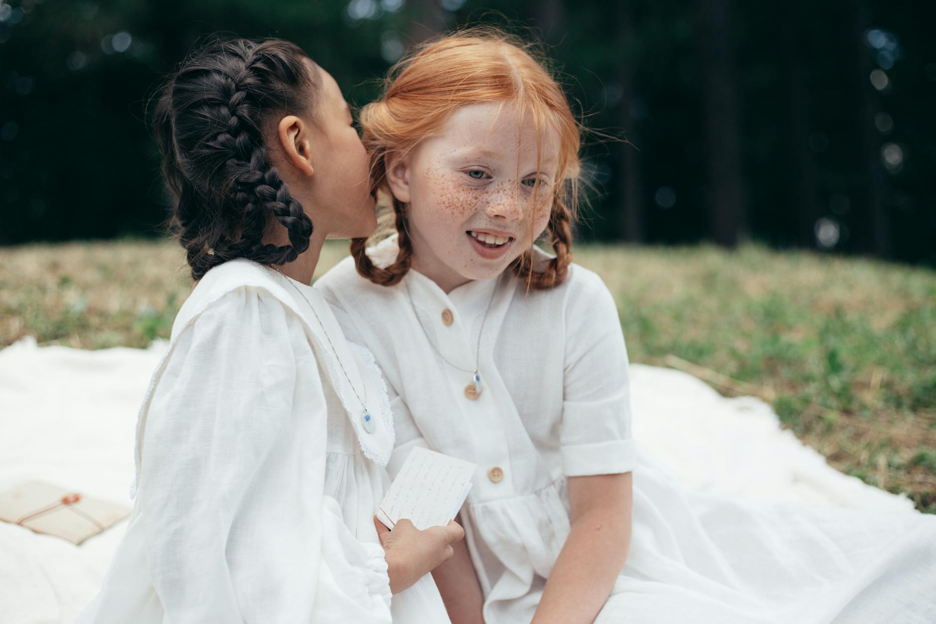 girl whispering to ear of friend