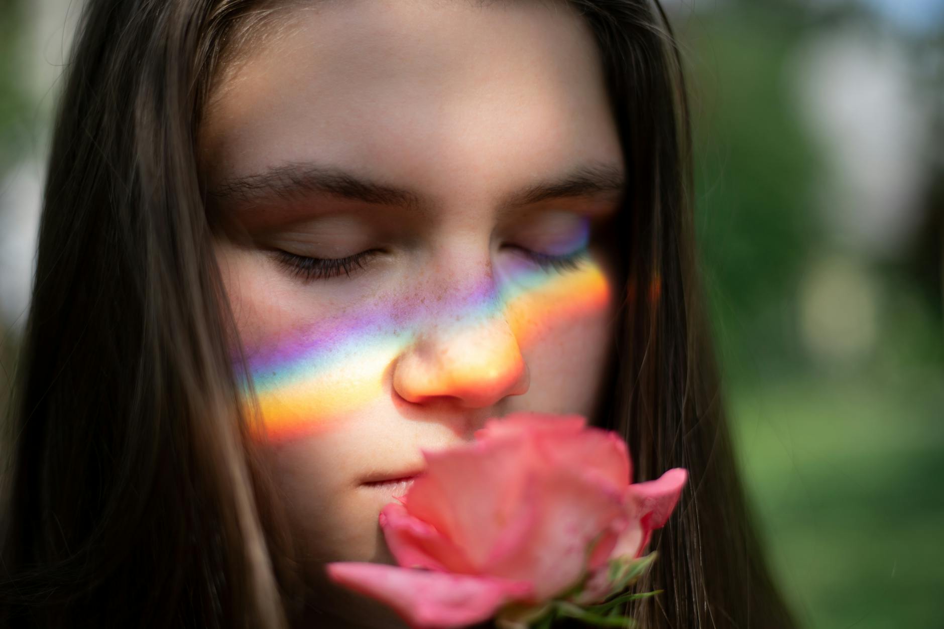 close up photography of woman smelling pink rose