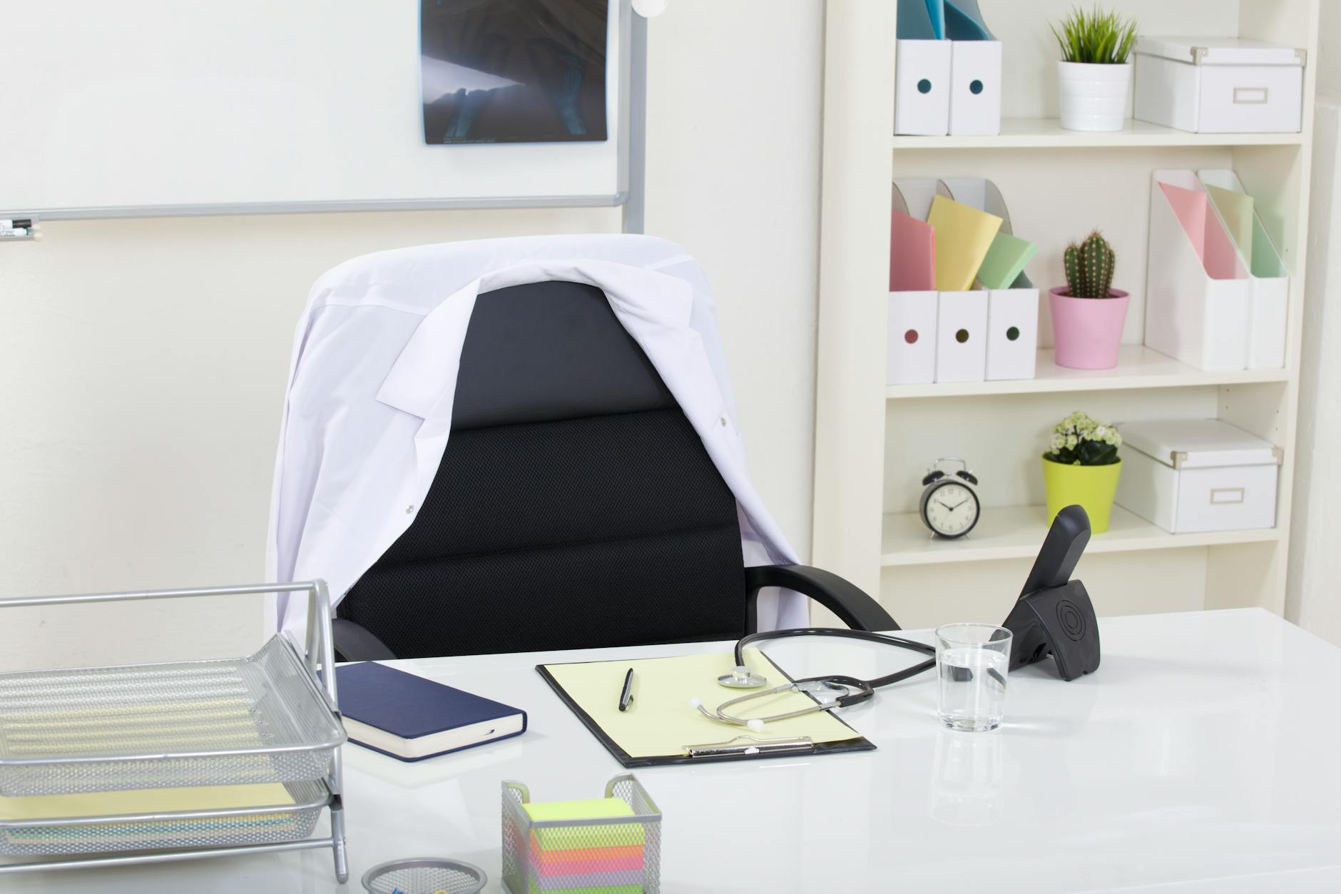 doctor office table desk and black chair with stethoscope and white paper