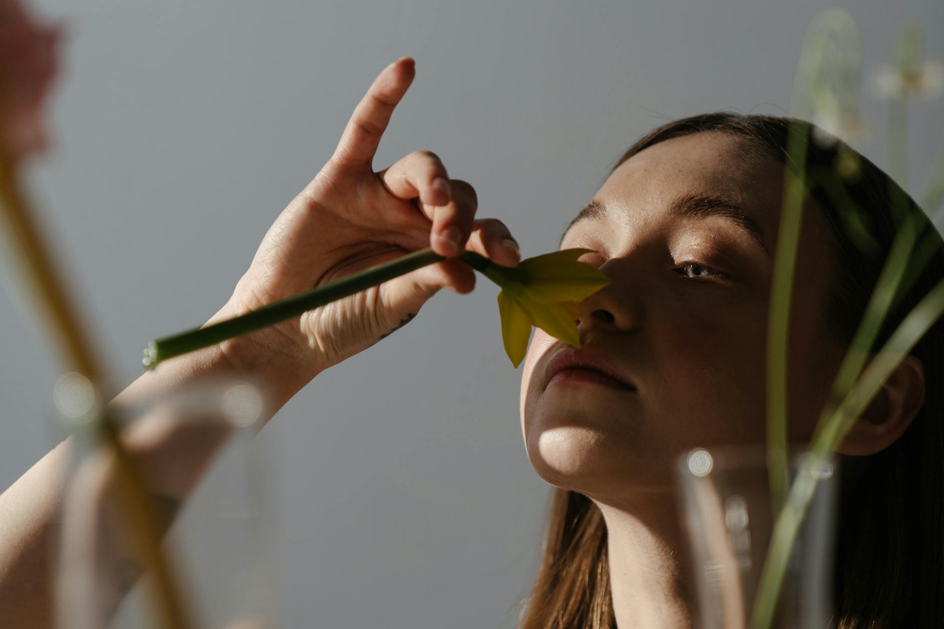 woman holding while smelling yellow and green flower